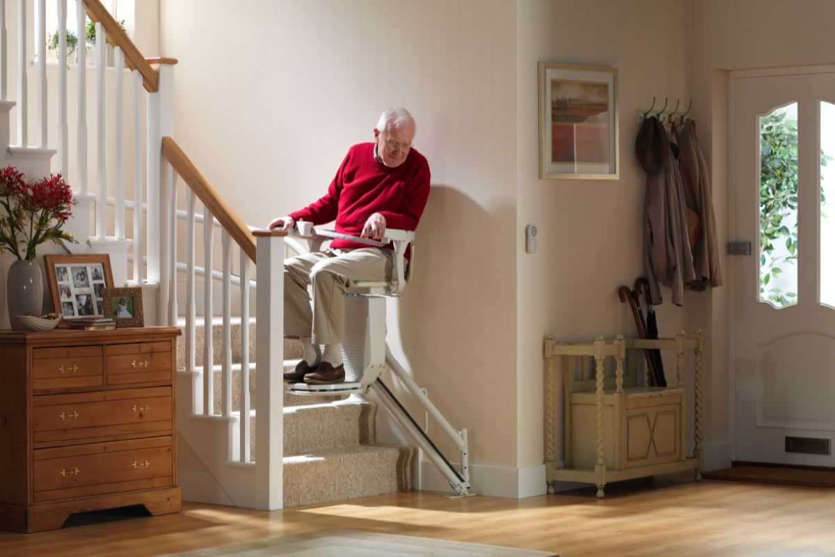 Homme utilisant un monte-escalier Stannah dans son escalier droit