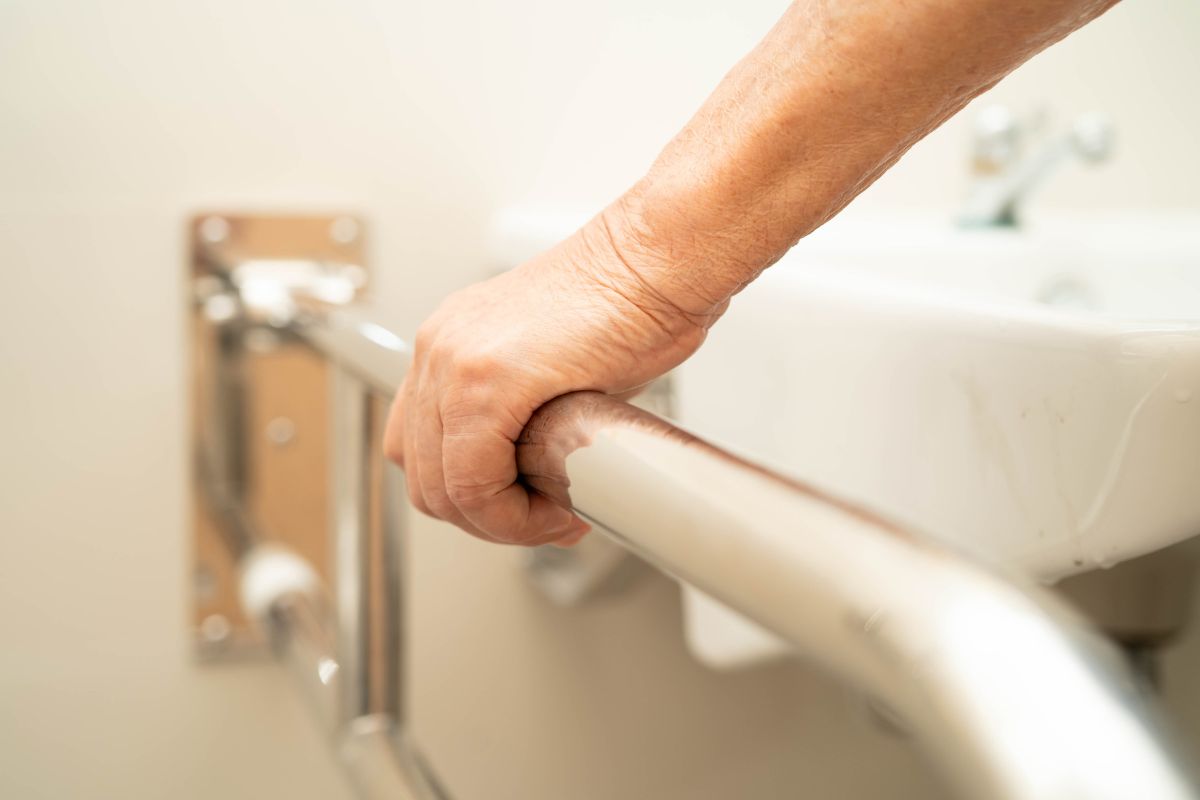Main tenant une barre d'appui dans la salle de bain