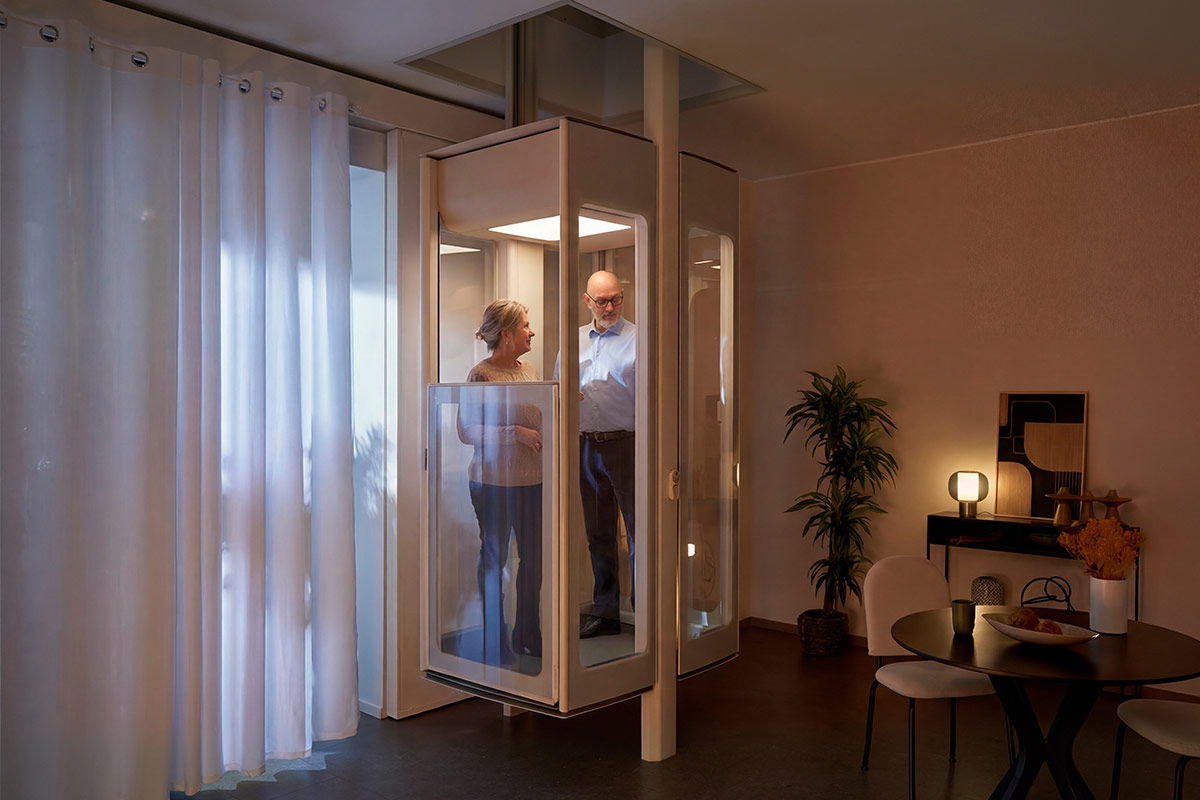 Couple de seniors dans un ascenseur de maison Stannah vitré, installé dans un salon chaleureux